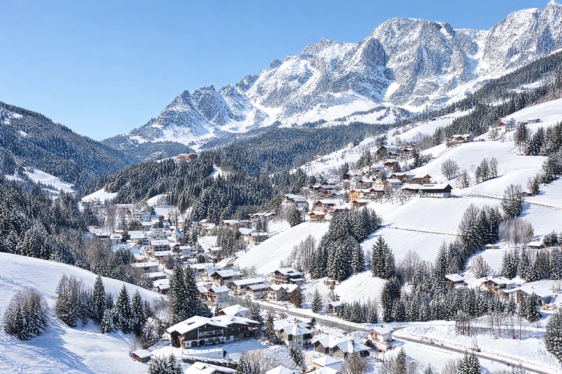 Alpenlandschap met Mühlbach am Hochkönig in het dal en besneeuwde bergtoppen