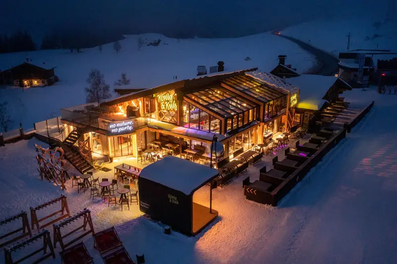 Beleuchtetes Restaurant in schneebedeckter Berglandschaft bei Nacht