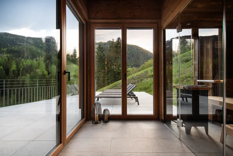 Vue depuis les baies panoramiques sur les montagnes vertes et les chaises longues