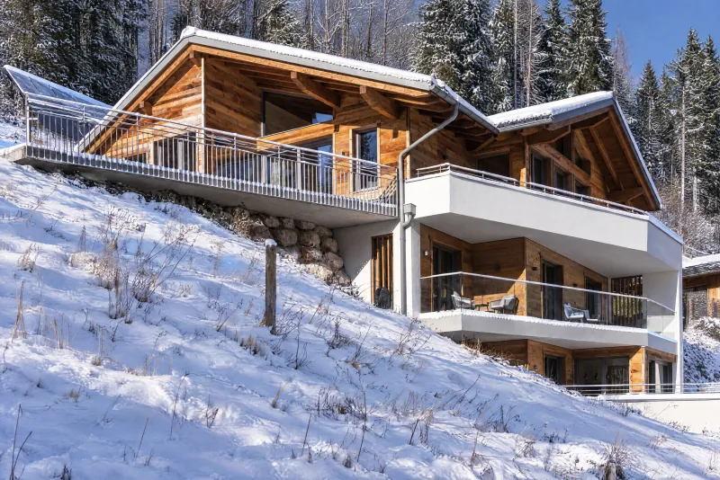 Le chalet et ses balcons sur le versant enneigé