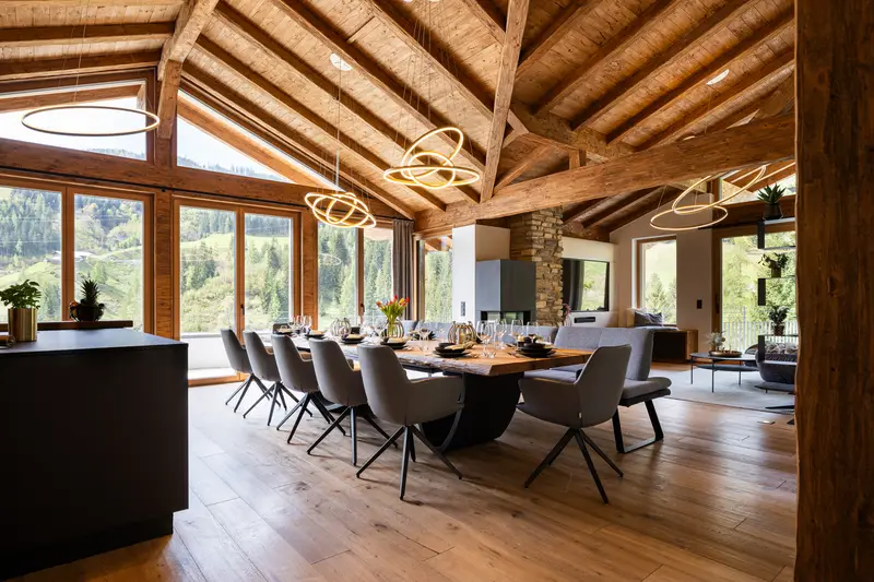 Coin repas avec plafond à poutres apparentes et table de quatre mètres en bois massif