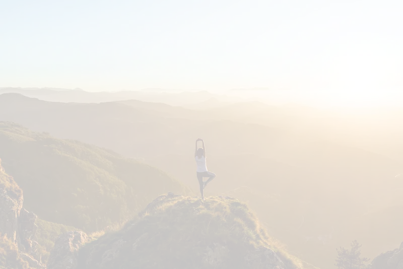 Vrouw tijdens een yogasessie op de berg bij zonsondergang