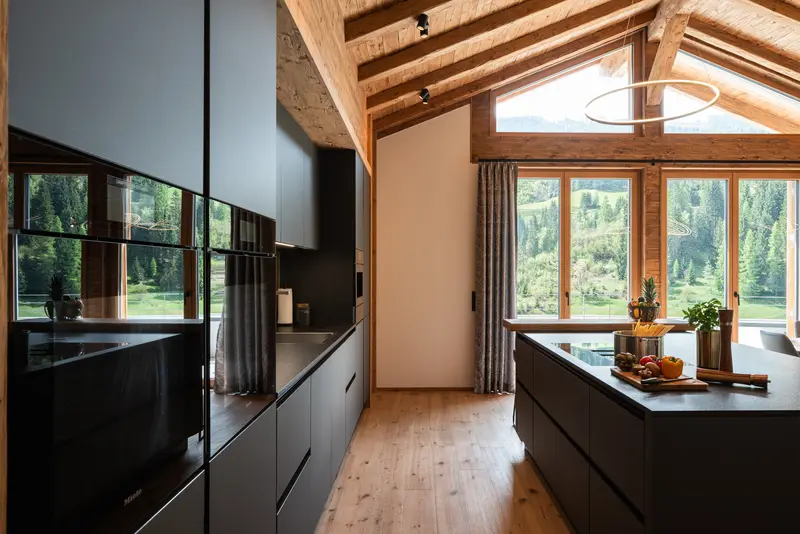 Chalet-Küche mit Holzbalken und Bergblick