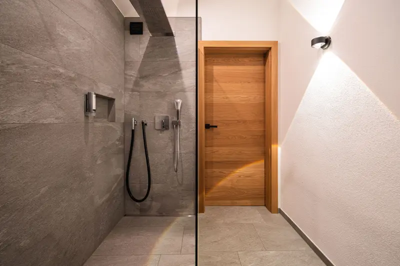 Douche moderne avec paroi vitrée et porte en bois