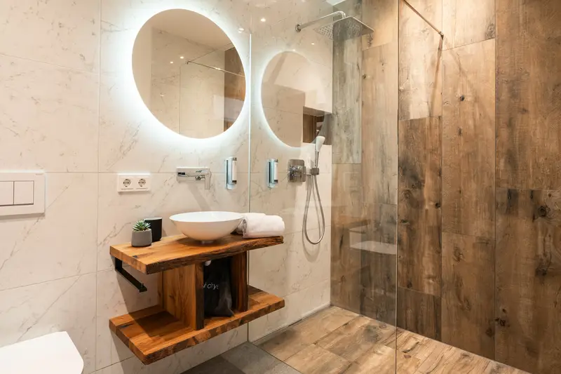 Salle de bains design avec vasque en bois et miroir éclairé