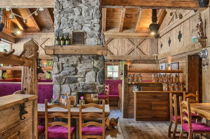 Rustikale Gaststube mit Steinkamin und Holzeinrichtung
