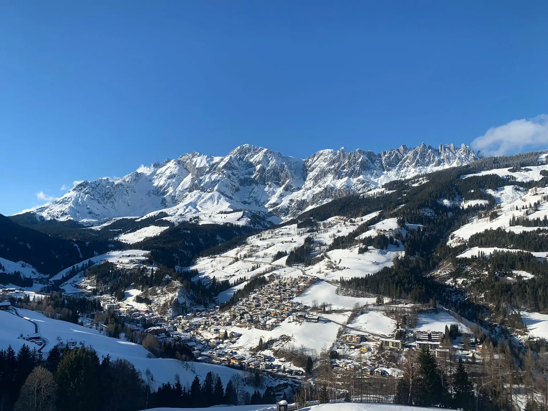 Schneebedeckte Alpen mit Dorf im Tal