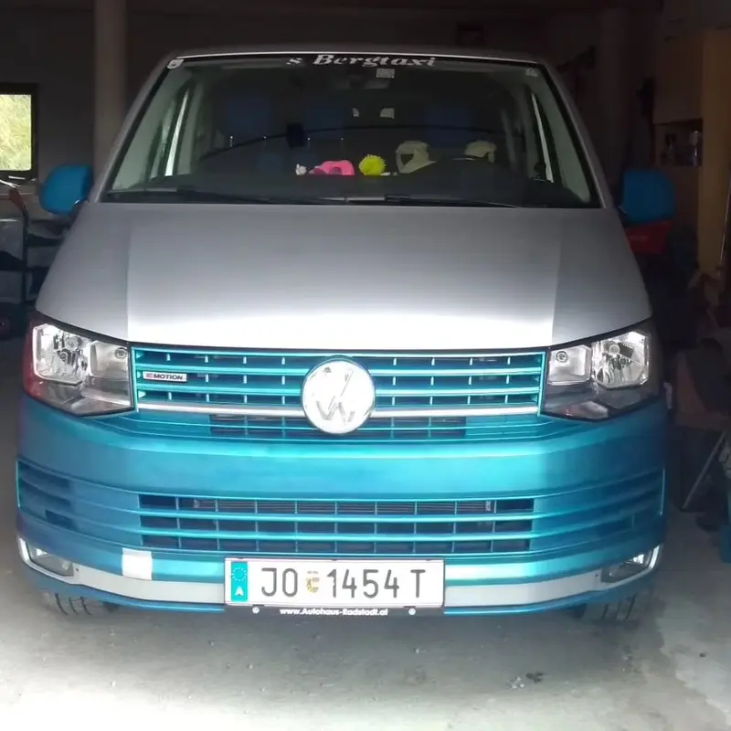 حافلة فولكس فاغن بلونين فضي وفيروزي لخدمة s’Bergtaxi من الأمام