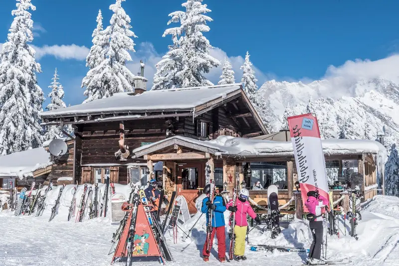 Skihütte mit Skifahrern im Schnee
